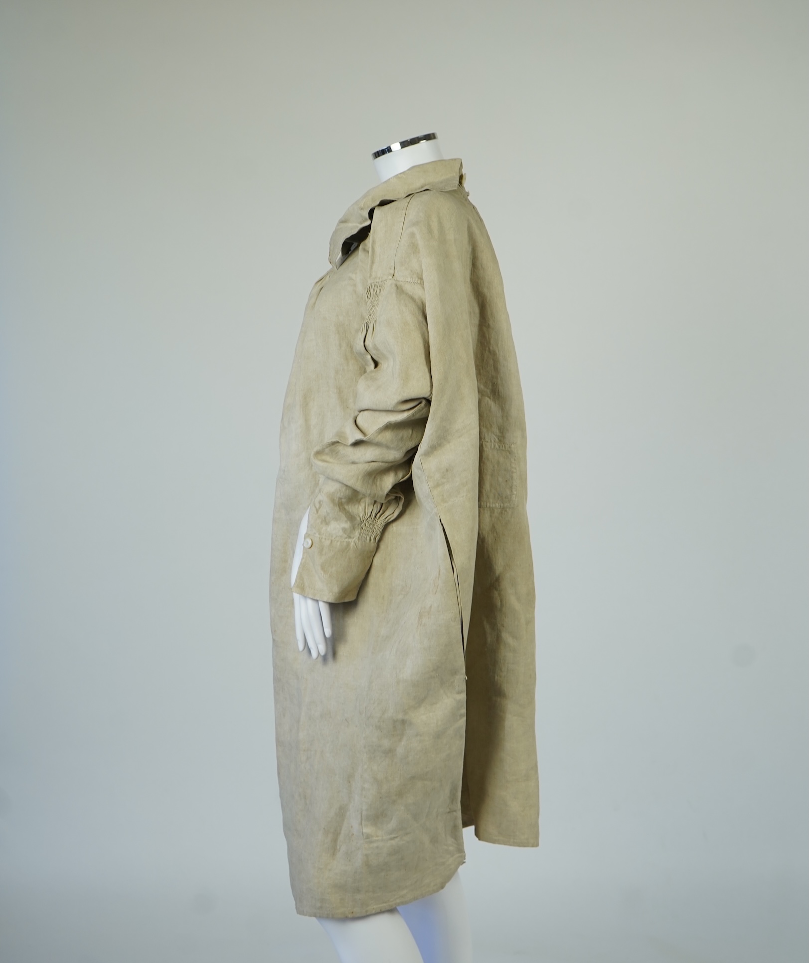 A 19th century heavy linen Shepherd’s smock, with small smocked shoulders and front and back neck panels under collar., 97cm long. Condition - patched and small darn near top and minor wear, usual for age and use.